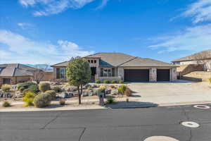 View of front of home with stone siding, driveway, an attached garage, and a tiled roof