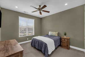Carpeted bedroom featuring a ceiling fan and recessed lighting