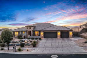 Prairie-style home with stone siding, an attached garage, and concrete driveway