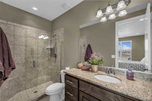 Ensuite bathroom with vanity, a stall shower, and recessed lighting