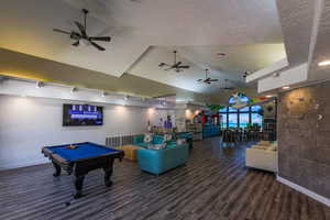 Recreation room featuring a ceiling fan, billiards table, high vaulted ceiling, and a textured ceiling