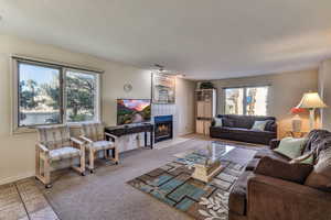 Carpeted living area with a tiled fireplace and a textured ceiling
