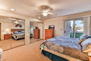Carpeted bedroom featuring two closets, access to exterior, ceiling fan, and a textured ceiling