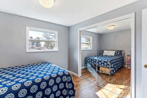 Bedroom with wood finished floors and a closet
