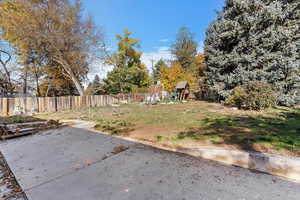 Fenced backyard featuring a playground