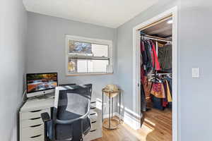 Office area with light wood-style flooring and baseboards