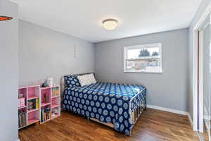 Bedroom with dark wood finished floors and baseboards