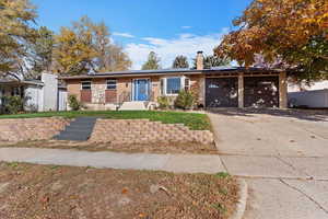 Single story home with solar panels, a chimney, concrete driveway, a garage, and brick siding