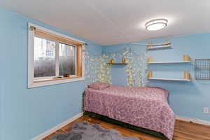 Bedroom featuring baseboards and wood finished floors