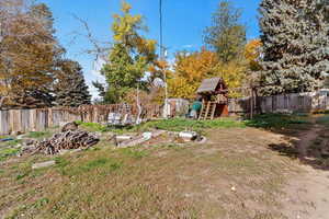 Fenced backyard featuring a playground