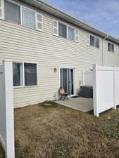 Rear view of house with a lawn and a patio