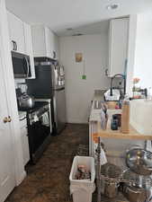 Kitchen with white cabinets, appliances with stainless steel finishes, and a textured ceiling