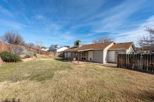 Rear view of property featuring a patio area, roof with shingles, and a fenced backyard