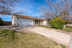 Ranch-style house featuring concrete driveway and a garage