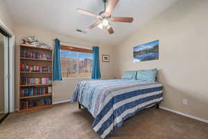Bedroom with vaulted ceiling, carpet flooring, and a ceiling fan