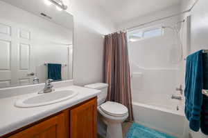 Bathroom with vanity, shower / bath combo, and light tile patterned floors