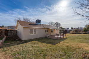 Rear view of property with a patio area, roof with shingles, and a fenced backyard
