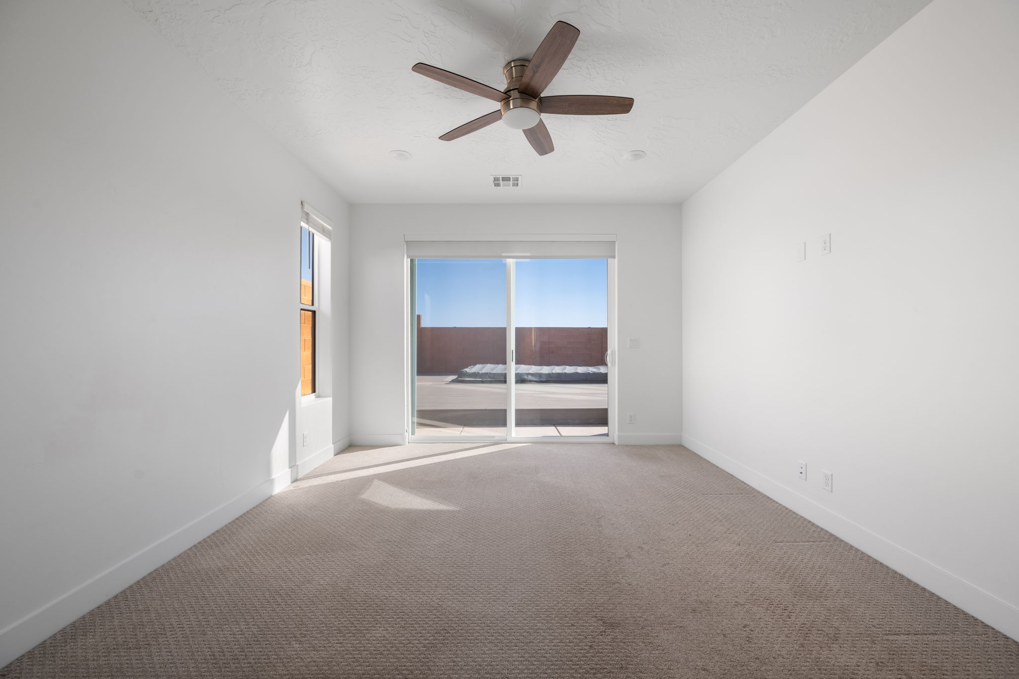 Empty room with carpet flooring and ceiling fan