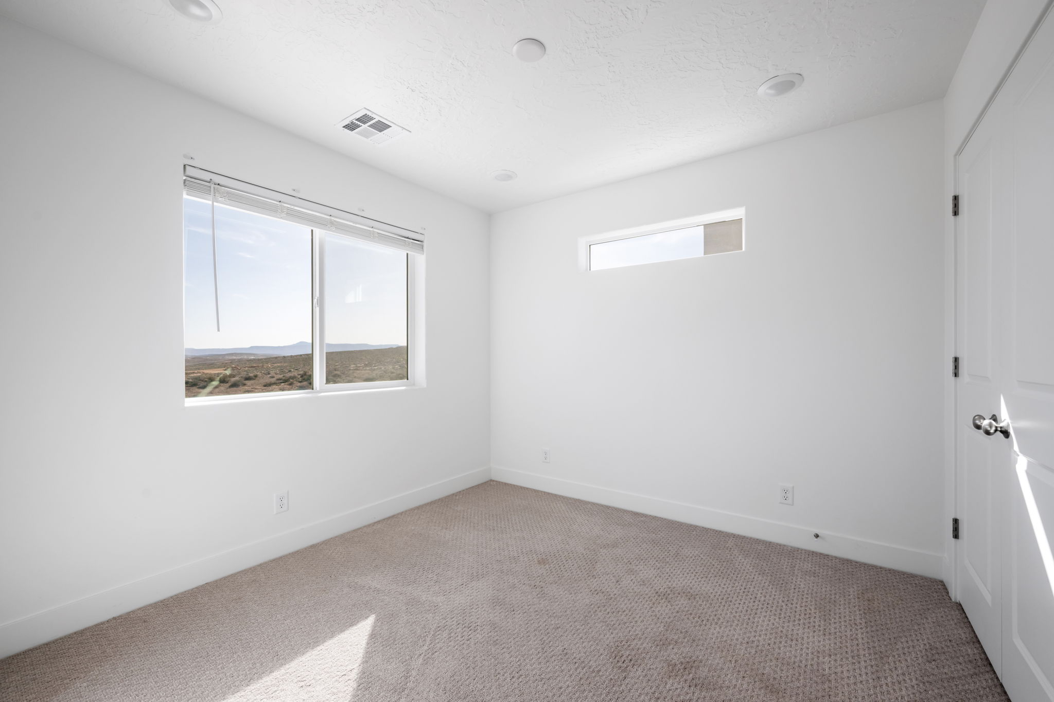 Spare room featuring carpet and baseboards