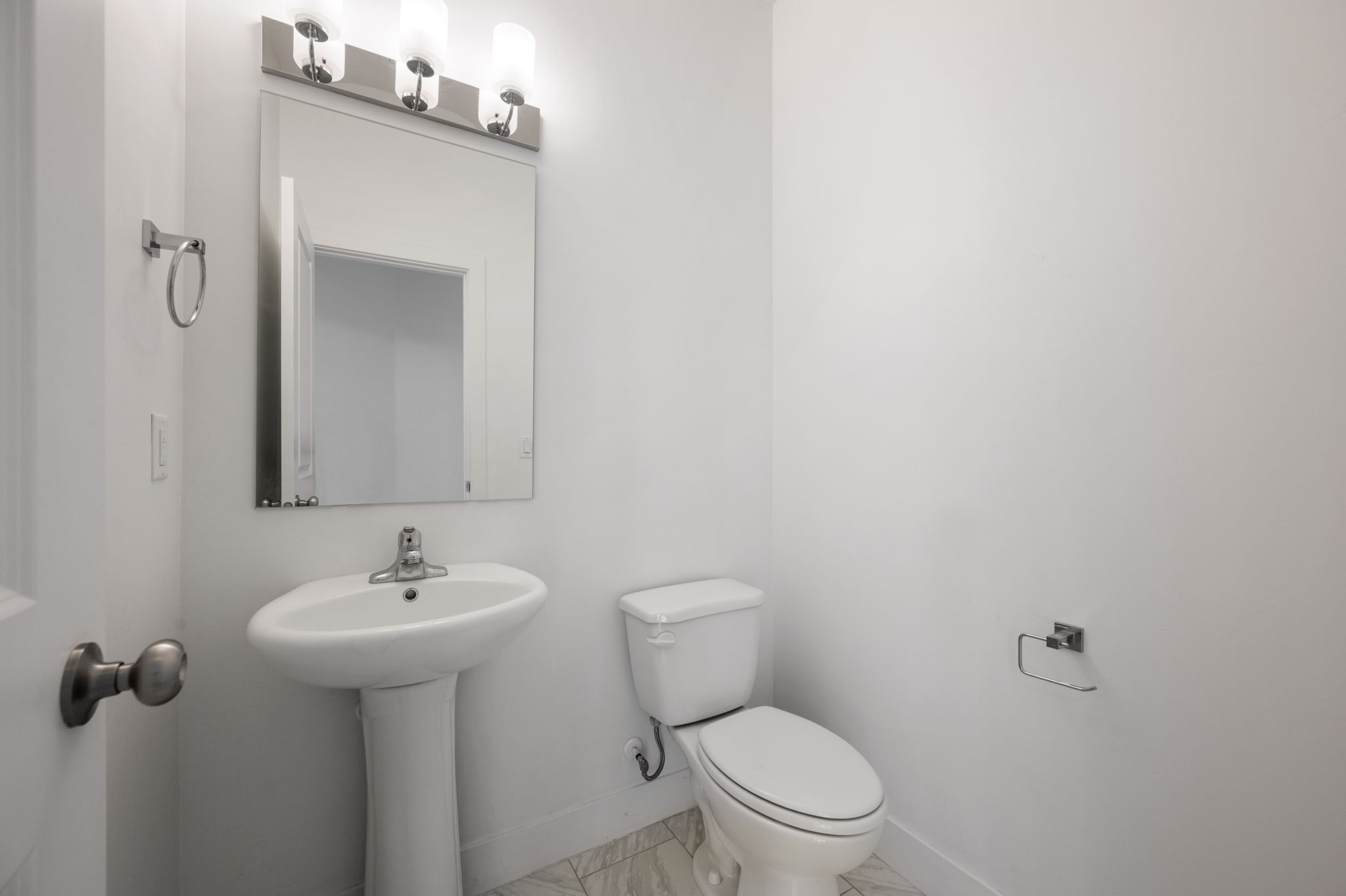 Half bathroom with toilet and marble look tile flooring