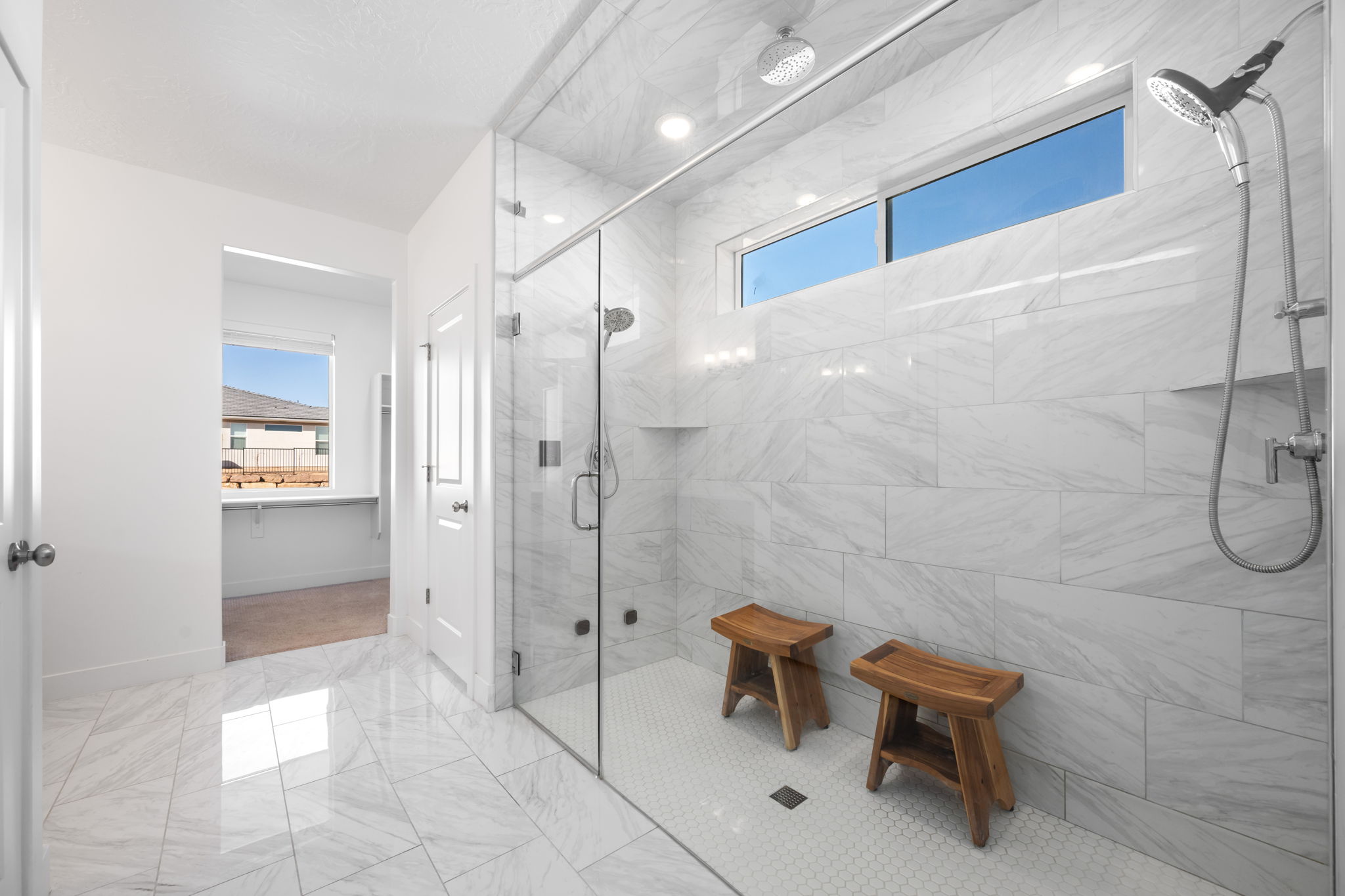 Bathroom featuring a shower stall and light marble finish flooring