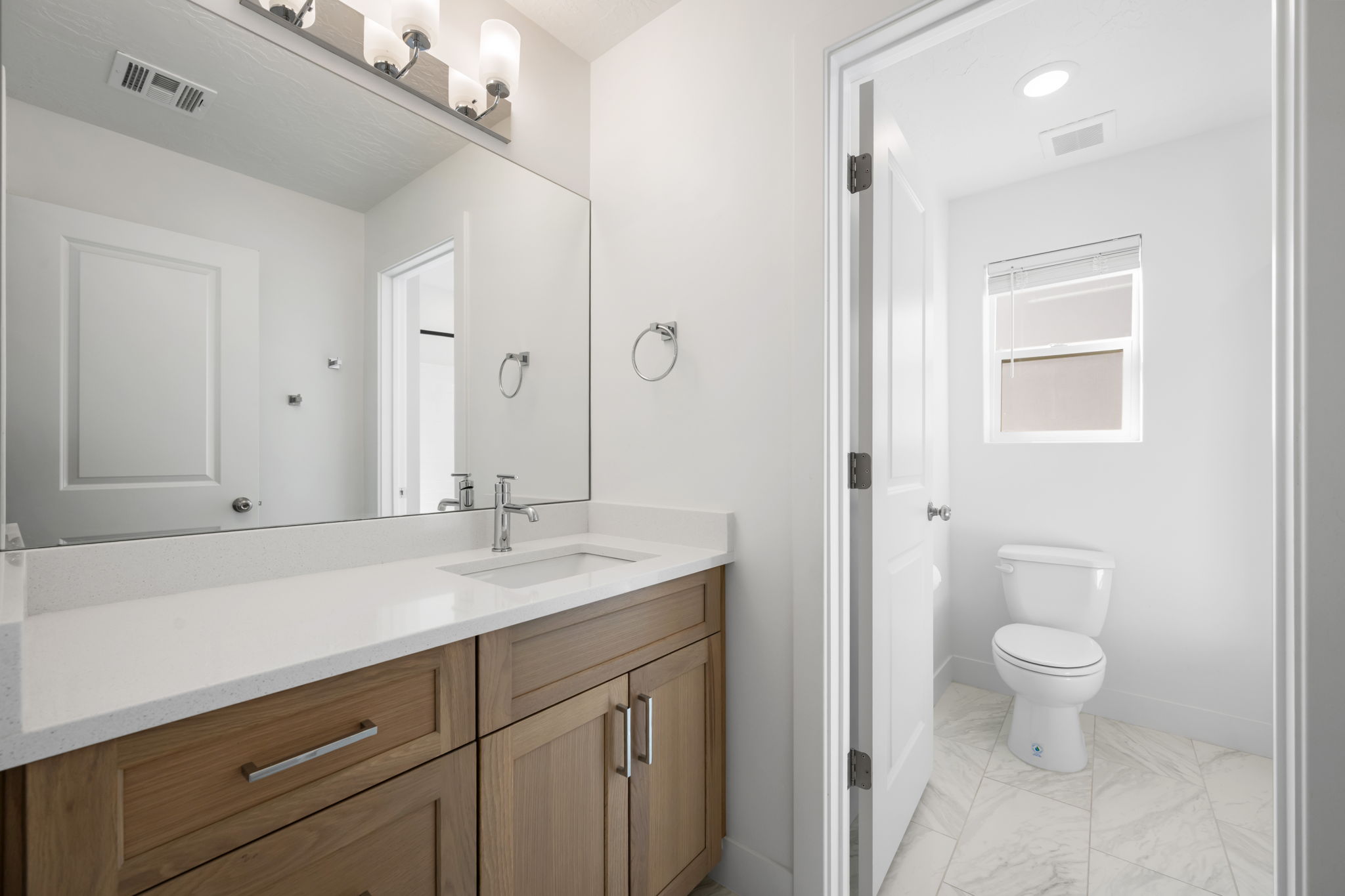 Full bathroom featuring vanity and light marble finish flooring