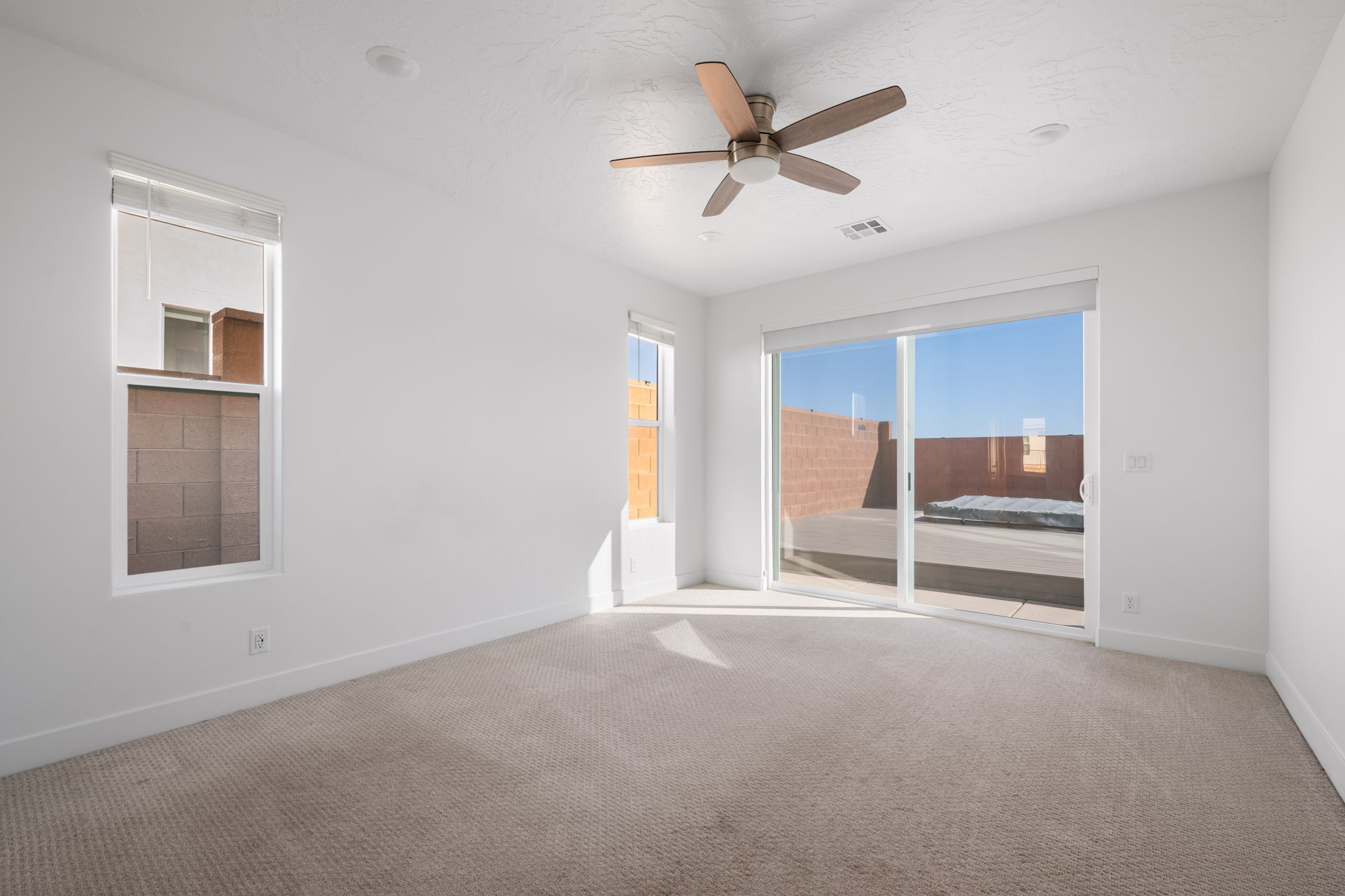 Carpeted empty room with ceiling fan and baseboards