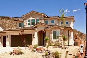 Mediterranean / spanish house with stone siding, stucco siding, concrete driveway, an attached garage, and a tile roof