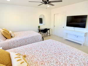 Bedroom with light colored carpet, ceiling fan, a closet, and recessed lighting