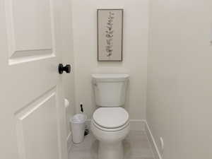 Bathroom with toilet and light tile patterned floors