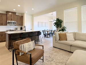 Living area with light wood-style floors and a chandelier