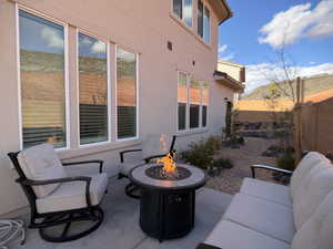 Fenced backyard featuring a patio area and a fire pit