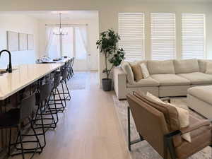 Living area with light wood-style flooring and hanging lights