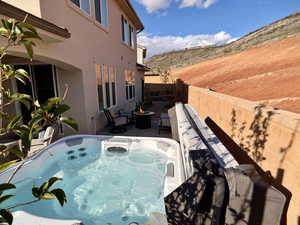 View of patio / terrace featuring a hot tub and an outdoor living space with a fire pit