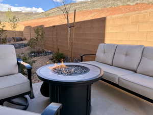 Fenced backyard with an outdoor living space with a fire pit and a patio