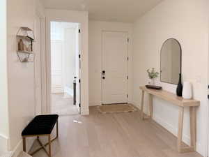Foyer entrance with light wood-style floors and baseboards