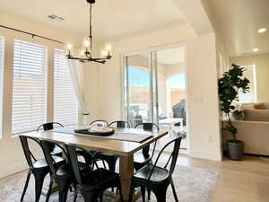 Dining room with light wood-style flooring and hanging lights
