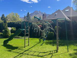 View of playground featuring a lawn and a mountain view