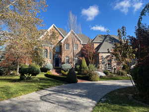 View of front of home featuring a front lawn, brick siding, and a shingled roof