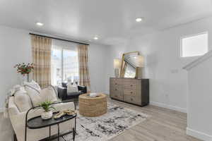 Living room featuring light wood-style floors, recessed lighting, and a textured ceiling