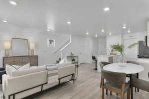 Living room with stairs, light wood-style flooring, recessed lighting, and a textured ceiling
