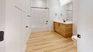 Full bathroom featuring vanity, light wood-type flooring, and shower / bathtub combination