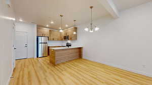 Kitchen with a peninsula, light wood-style floors, stainless steel appliances, modern cabinets, and light wood finish cabinets