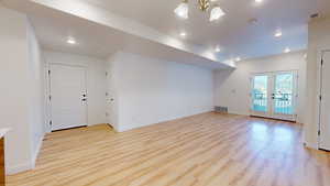 Unfurnished living room featuring french doors, light wood-style floors, and recessed lighting