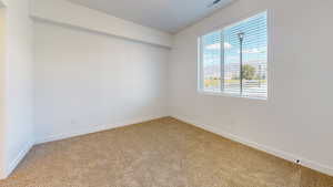 Carpeted empty room with baseboards