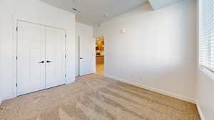 Unfurnished bedroom with carpet flooring and a closet