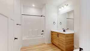 Full bath featuring light wood-type flooring, vanity, shower / bath combination, and recessed lighting