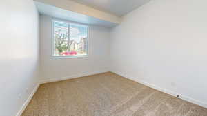 Carpeted spare room with baseboards