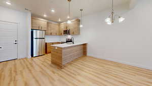 Kitchen with stainless steel appliances, modern cabinets, a peninsula, and light wood-type flooring