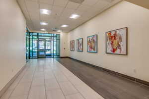 Building lobby with floor to ceiling windows and a paneled ceiling